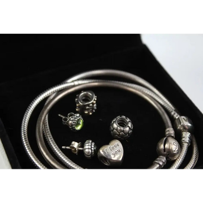 Silver bracelets and charms on a black background