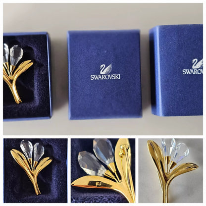 Gold and crystal brooch in a Swarovski box with close-up views.