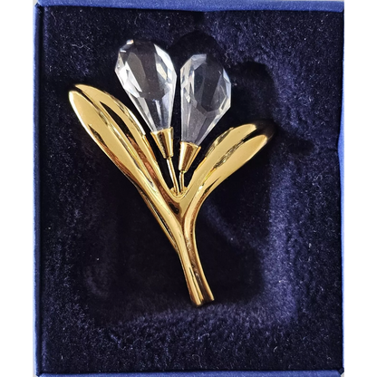 Gold and crystal brooch on a dark blue background