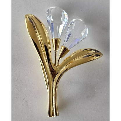 Gold and crystal decorative item on a light gray background