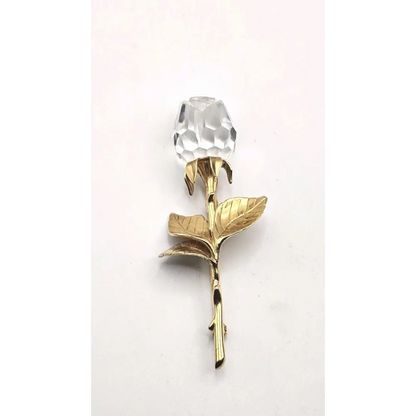 Gold rose-shaped object with a clear crystal 