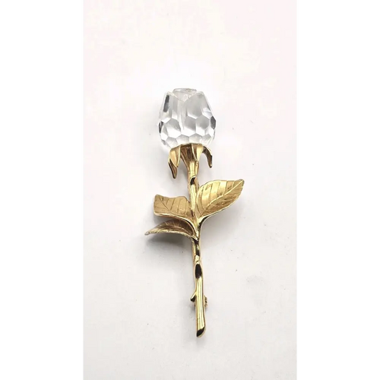 Gold rose-shaped object with a clear crystal 