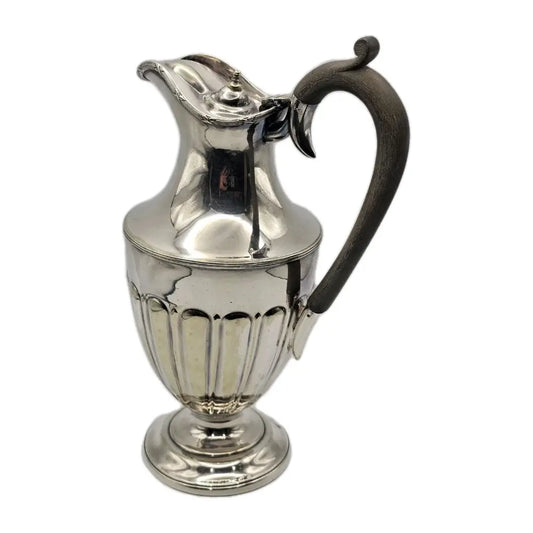Silver pitcher with a black handle