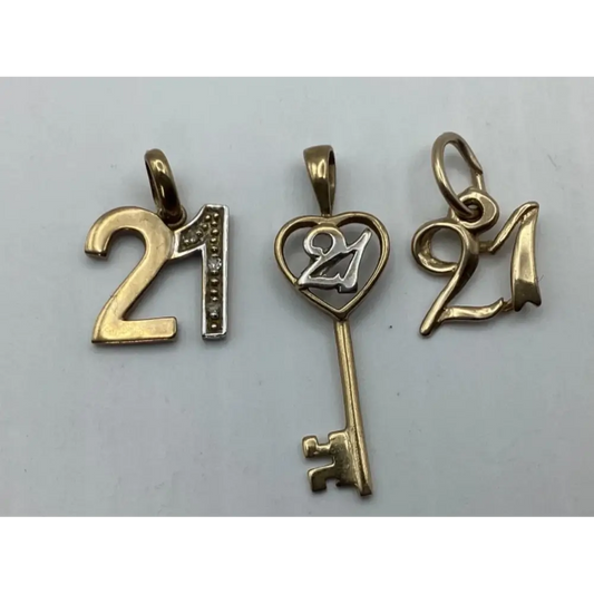 Three gold '21' pendants on a light gray background