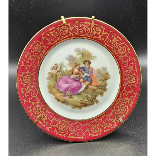 Decorative plate with a red and gold rim featuring