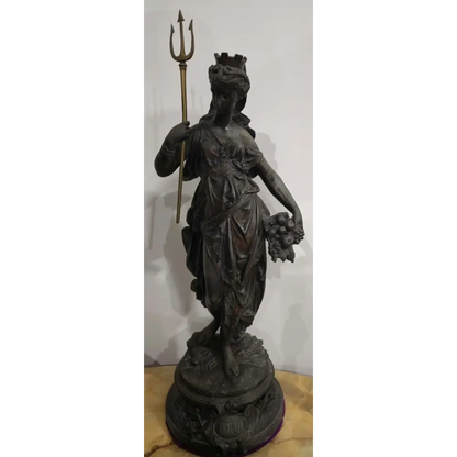 Statue of a figure holding a trident and fruit on a white background