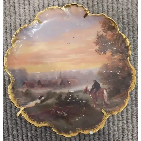 Decorative plate with a scenic painting of a village and people