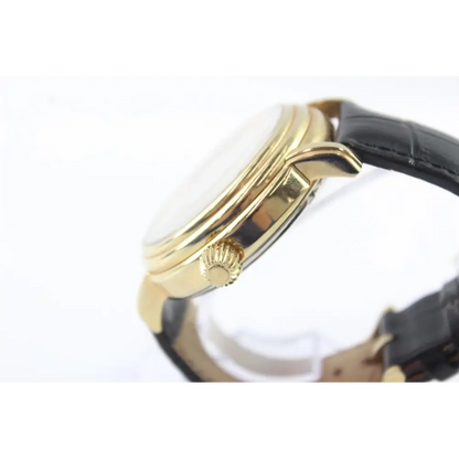 Close-up of a gold watch with a black strap