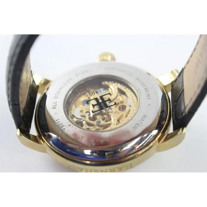 Close-up of a gold watch with a visible brand logo