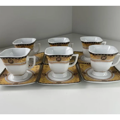Set of six white ceramic cups and saucers with gold and black patterns