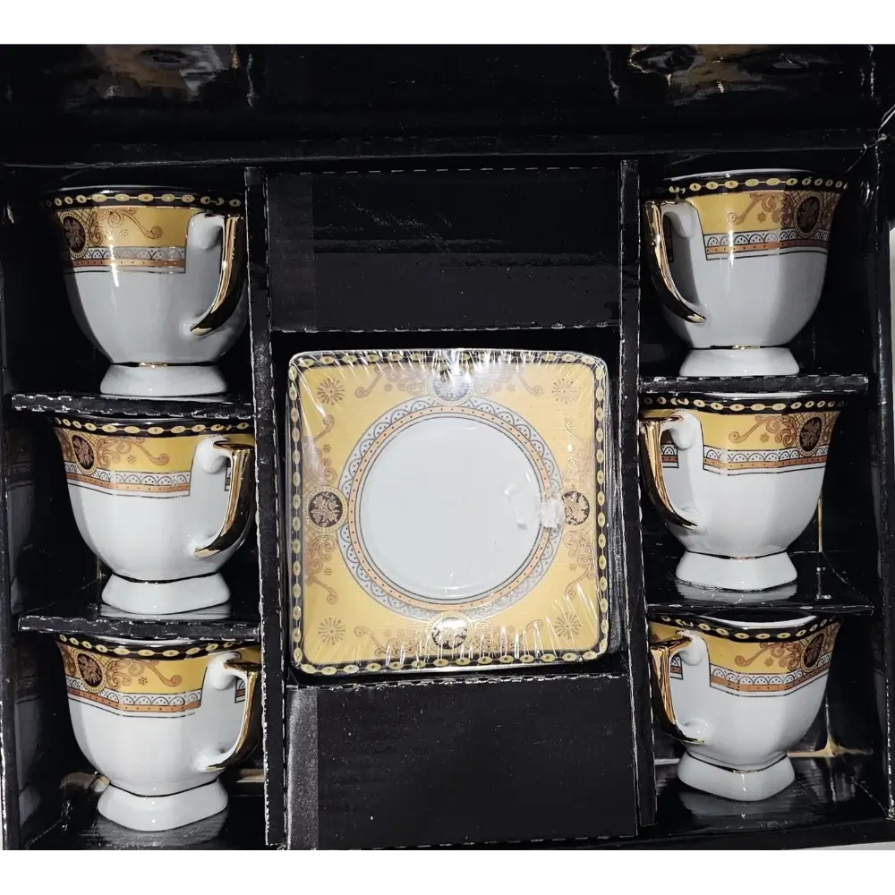 Set of white cups with gold and black decorative patterns in a black display box.