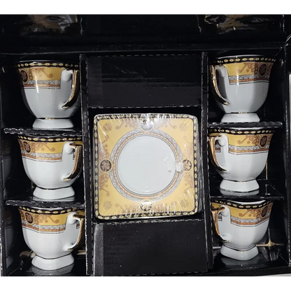 Set of white cups with gold and black decorative patterns in a black display box.