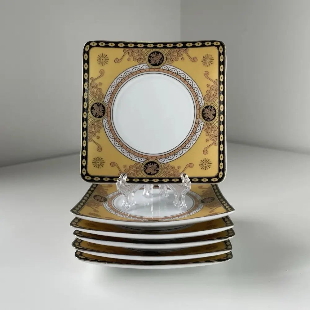 Set of decorative square plates with gold and black patterns