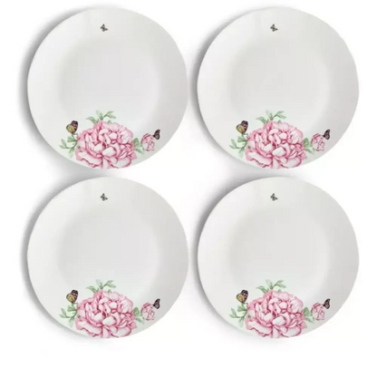Four white plates with pink floral designs 