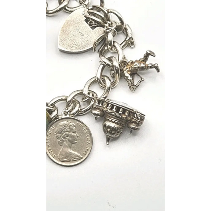 Silver charm bracelet with various charms on a white background