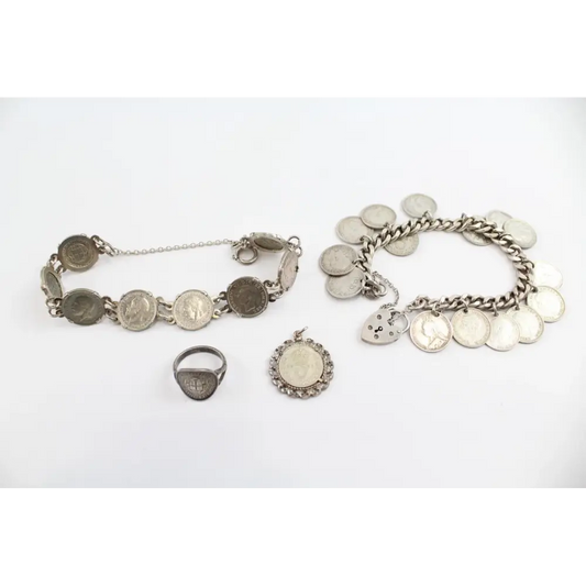 Silver bracelet and ring with coin charms on a white background