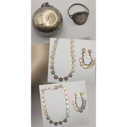 Silver jewelry set including necklaces, a ring, and a pendant on a white surface.