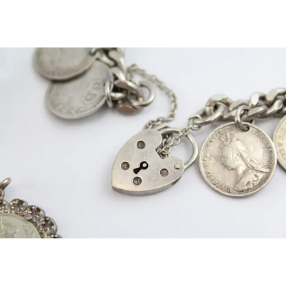 Silver bracelet with various charms including a heart-shaped lock charm