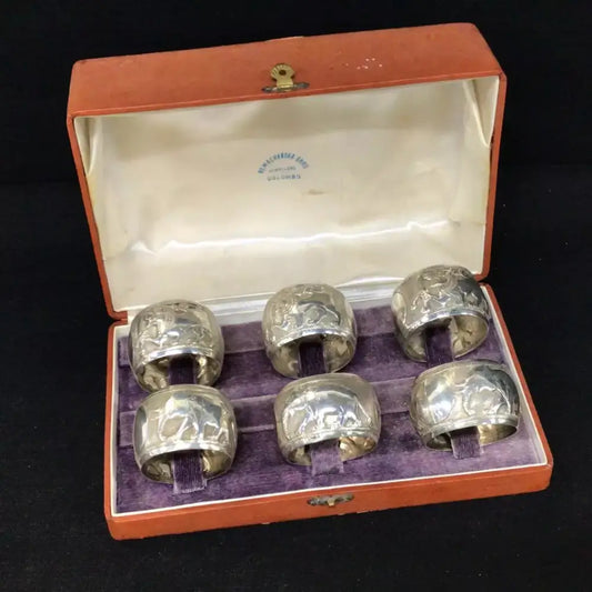 Set of six silver napkin rings in an open red box