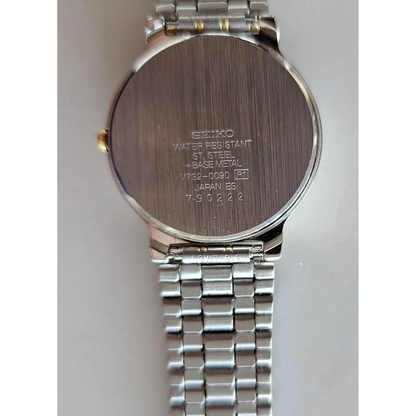 Back view of a Seiko watch with metal band on a light gray background