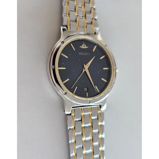 Two-tone silver and gold Seiko watch on a light gray background