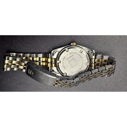 Two-tone watch with metal band on a gray background