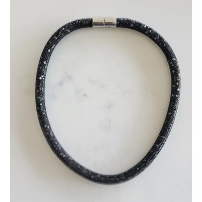 Black textured Necklace on a white marble surface