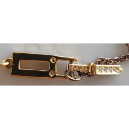 Gold bracelet with a clasp and Swarovski logo