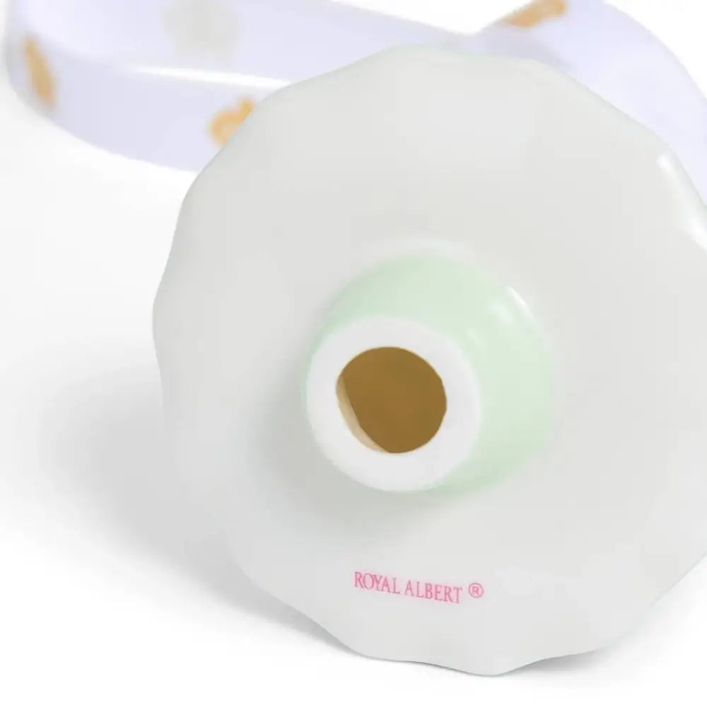 White ceramic object with a green light and 'Royal Albert' branding