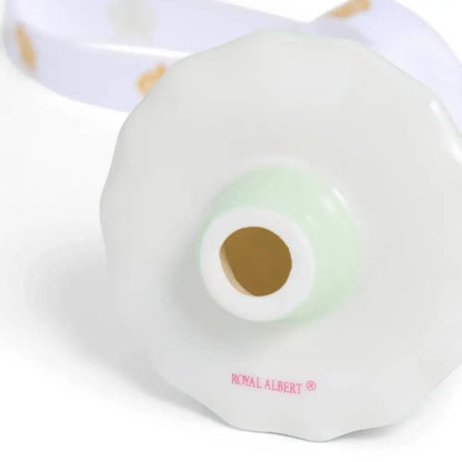 White ceramic object with a green light and 'Royal Albert' branding