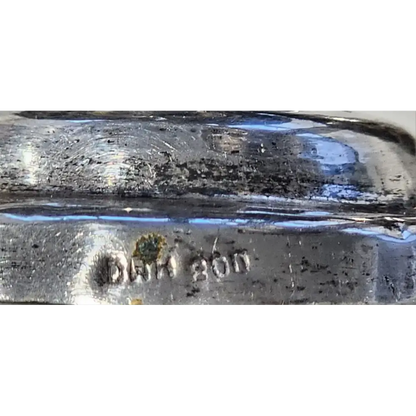 Close-up of a glass object with 'DAM 200' marking on a white background