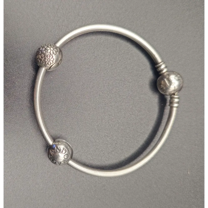 Silver bracelet with decorative beads on a gray background