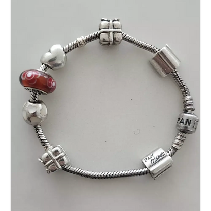 Silver bracelet with various charms on a light gray background