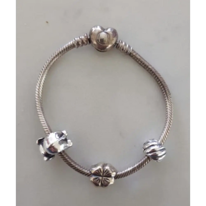 Silver bracelet with various charms on a light gray background