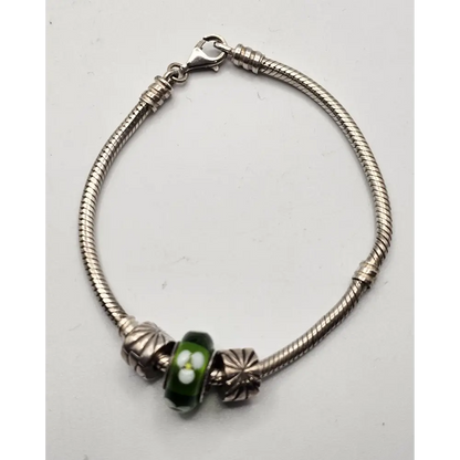 Silver bracelet with a green bead on a white background