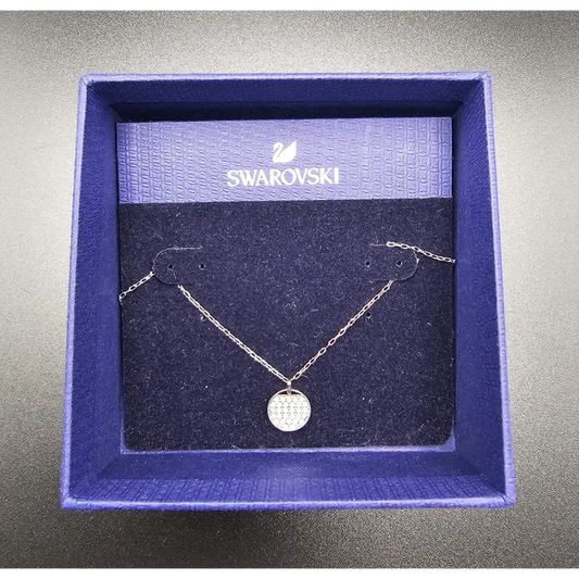 Swarovski necklace in a branded box on a gray background
