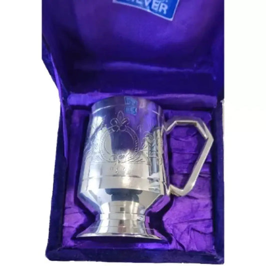 Silver tankard with decorative handle on purple fabric