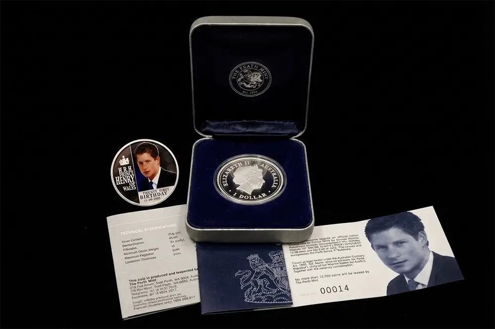 A silver commemorative coin presented in an open dark blue velvet box, with a matching round coin, printed cards, and a black background. The coin and packaging feature portraits of British Prime Minister Winston Churchill from our World & Vintage Coins collection