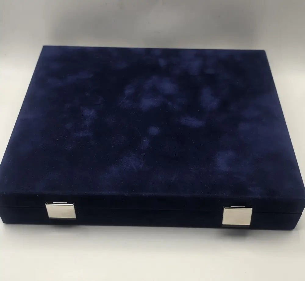 Navy blue velvet jewelry box with silver corners on a white background