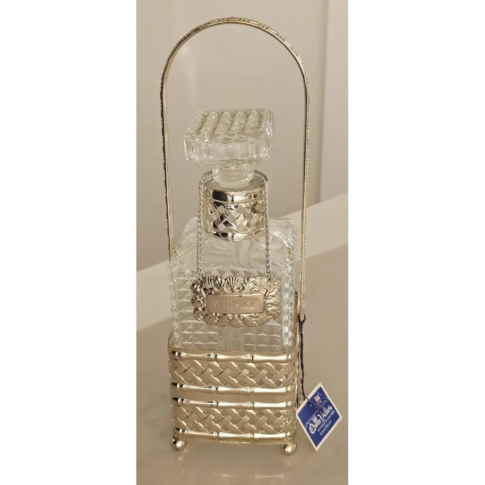 Decorative bottle holder with clear glass bottle and gold accents on a beige background