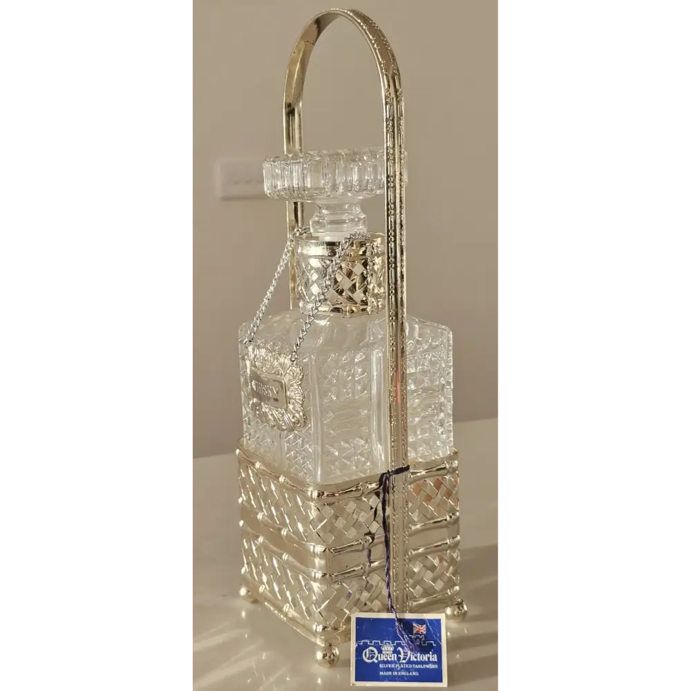 The vintage Queen Victoria whisky decanter displayed on a luxury dark wood bar cart.