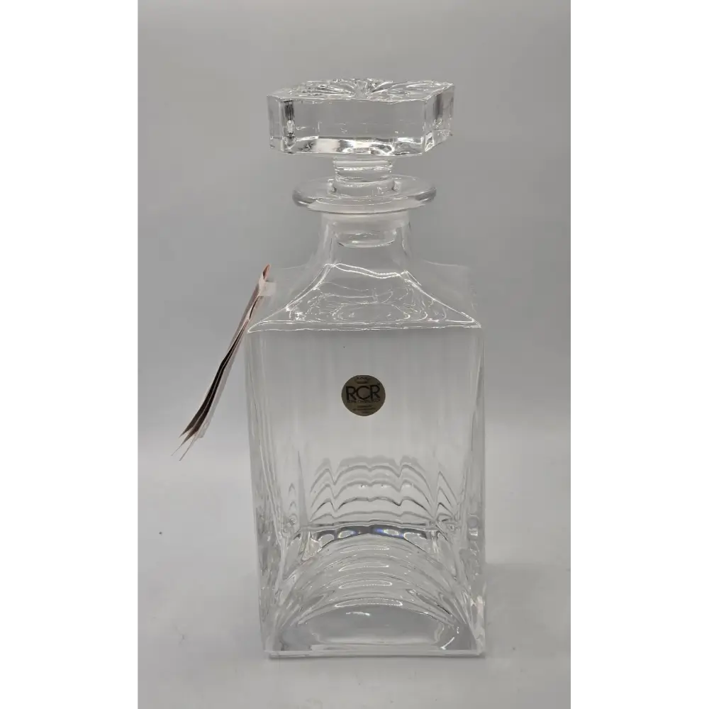 Clear glass decanter with a stopper on a gray background