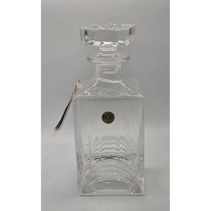 Clear glass decanter with a stopper on a gray background
