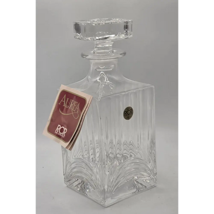 Clear glass decanter with a label on a gray background