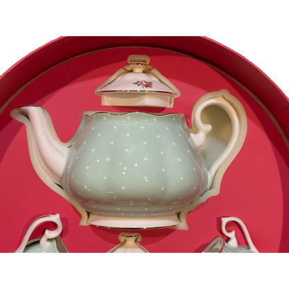 Decorative teapot with polka dot design on a red background