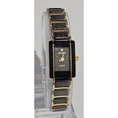 Gold and black watch on a clear stand