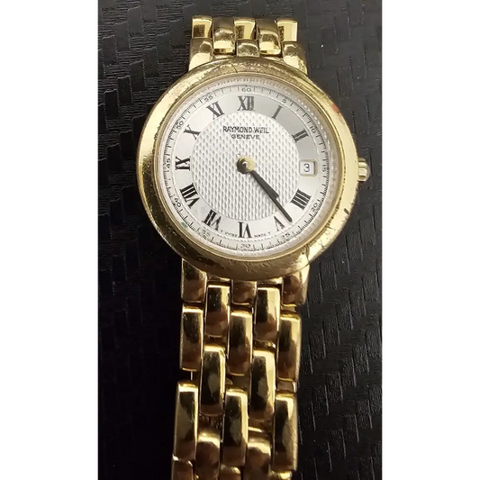 Gold wristwatch with a white face and Roman numerals on a black textured background