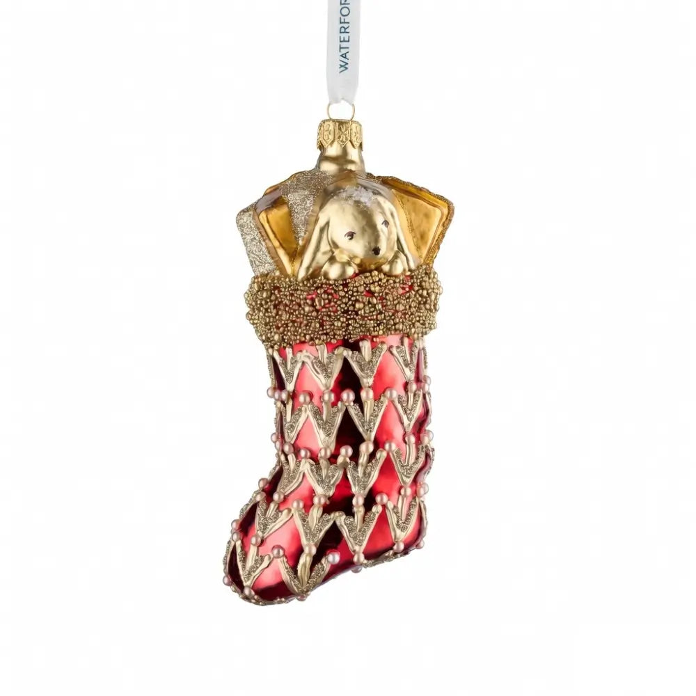 Decorative Christmas ornament shaped like a red dress with gold accents on a white background