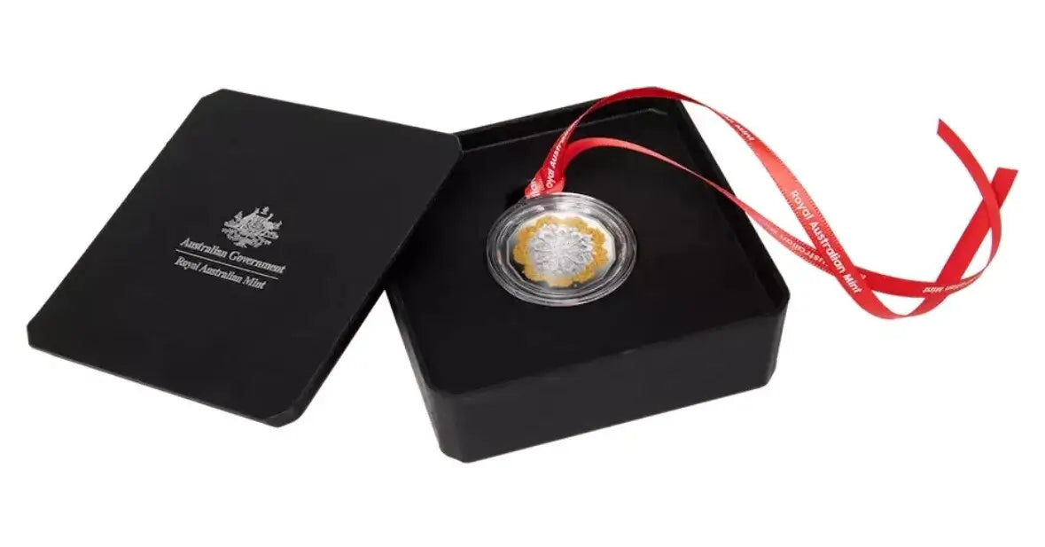 A silver and gold commemorative coin presented in an open black gift box with a red ribbon, on a white background. The lid of the box is visible on the left and features the Australian Government and Royal Australian Mint branding.