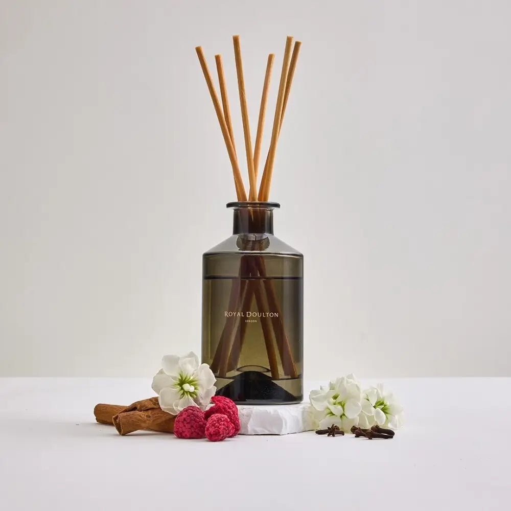 Diffuser with wooden sticks and decorative elements on a white background